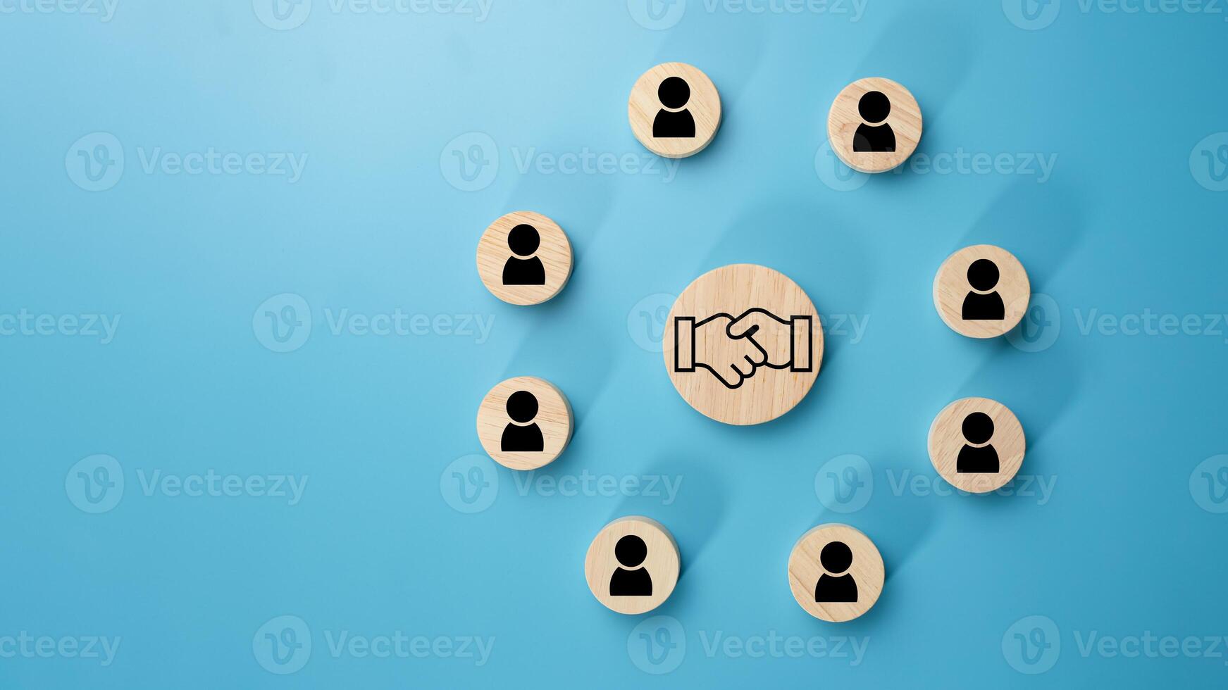 Team management concept, Human resources, Recruitment concept, HRM administration or human resource management concept, The handshake icon in a circular wooden board placed on a light blue background. photo