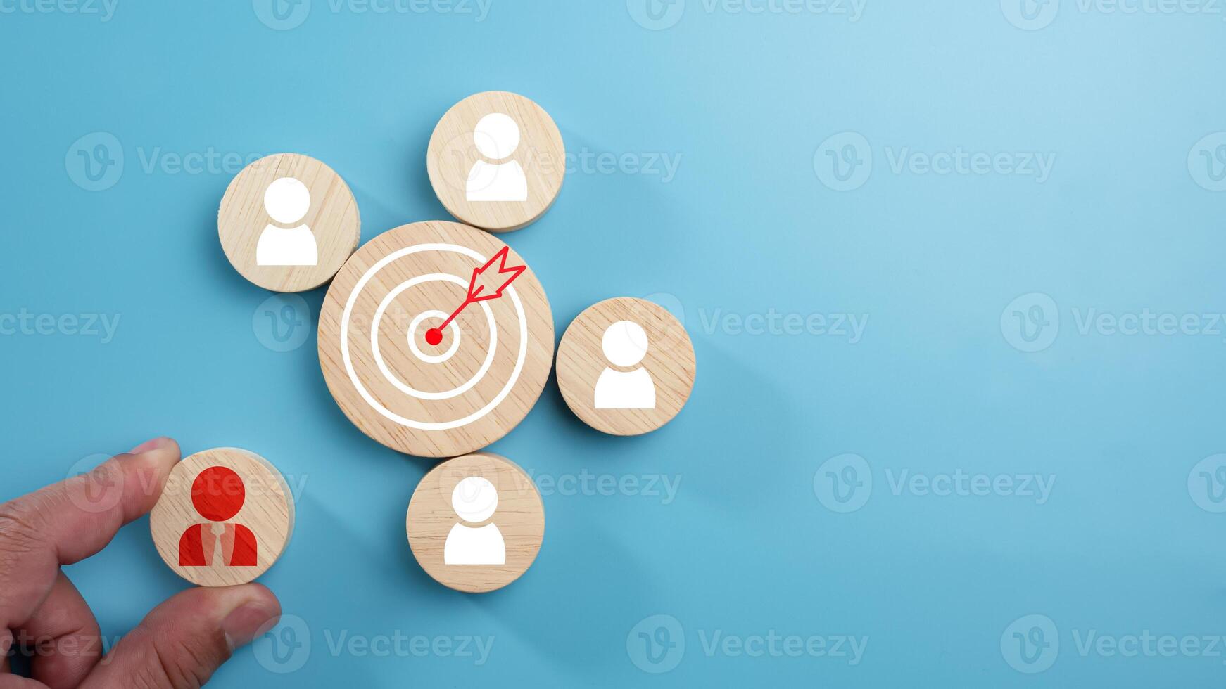 Circular wood with printed target icons and business symbols on light blue background, business goals and objectives concept, business competition, Customer relationship management concept. photo