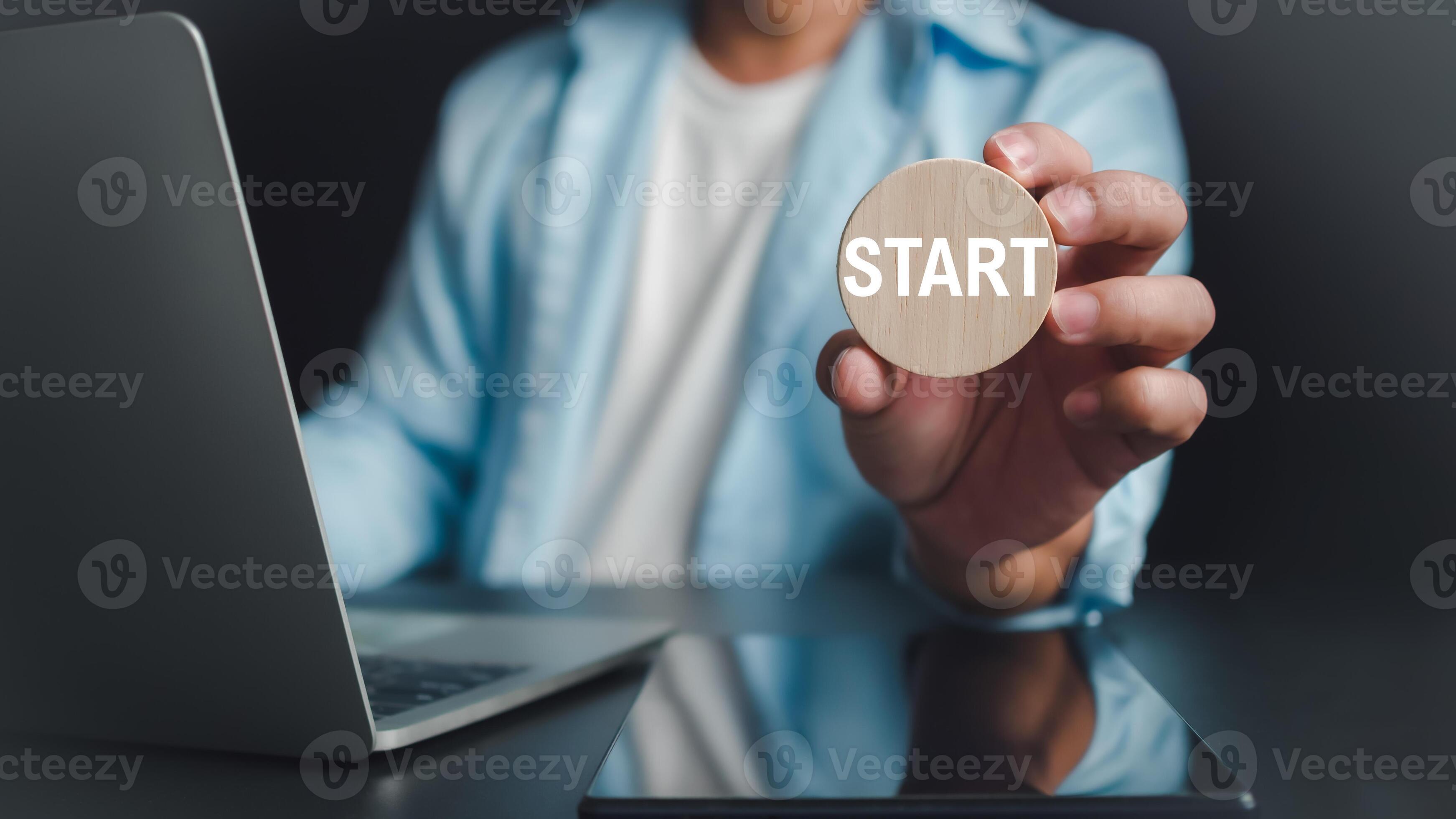 Goals When Starting A New Business Businessman showing circle wooden and start lettering on desk with