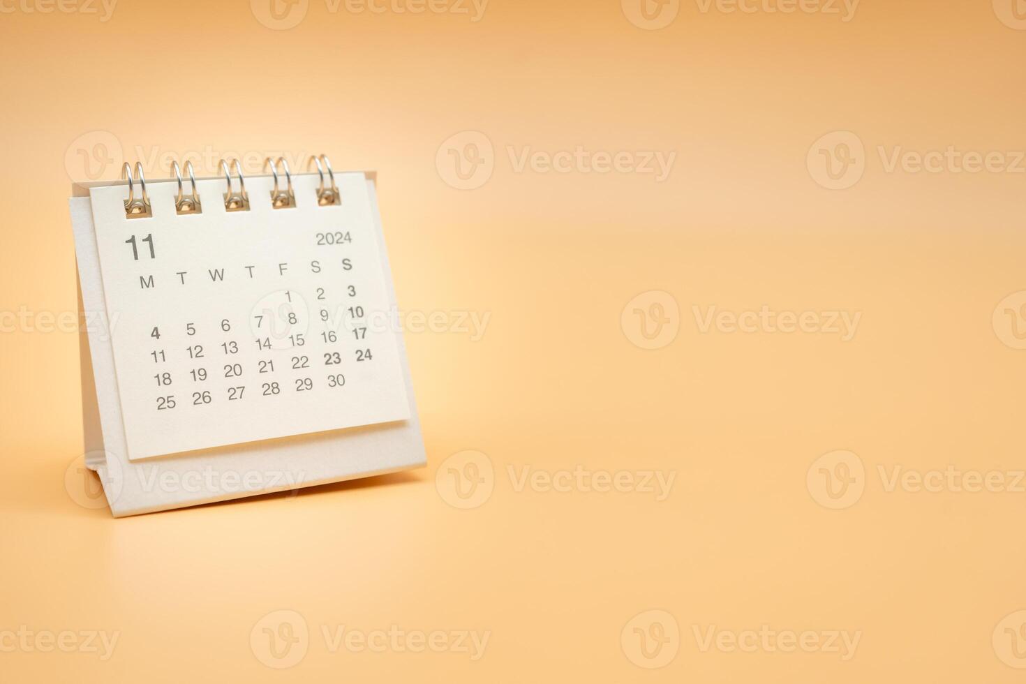 Simple desk calendar for November 2024 isolated on orange background. Calendar concept with copy space. photo