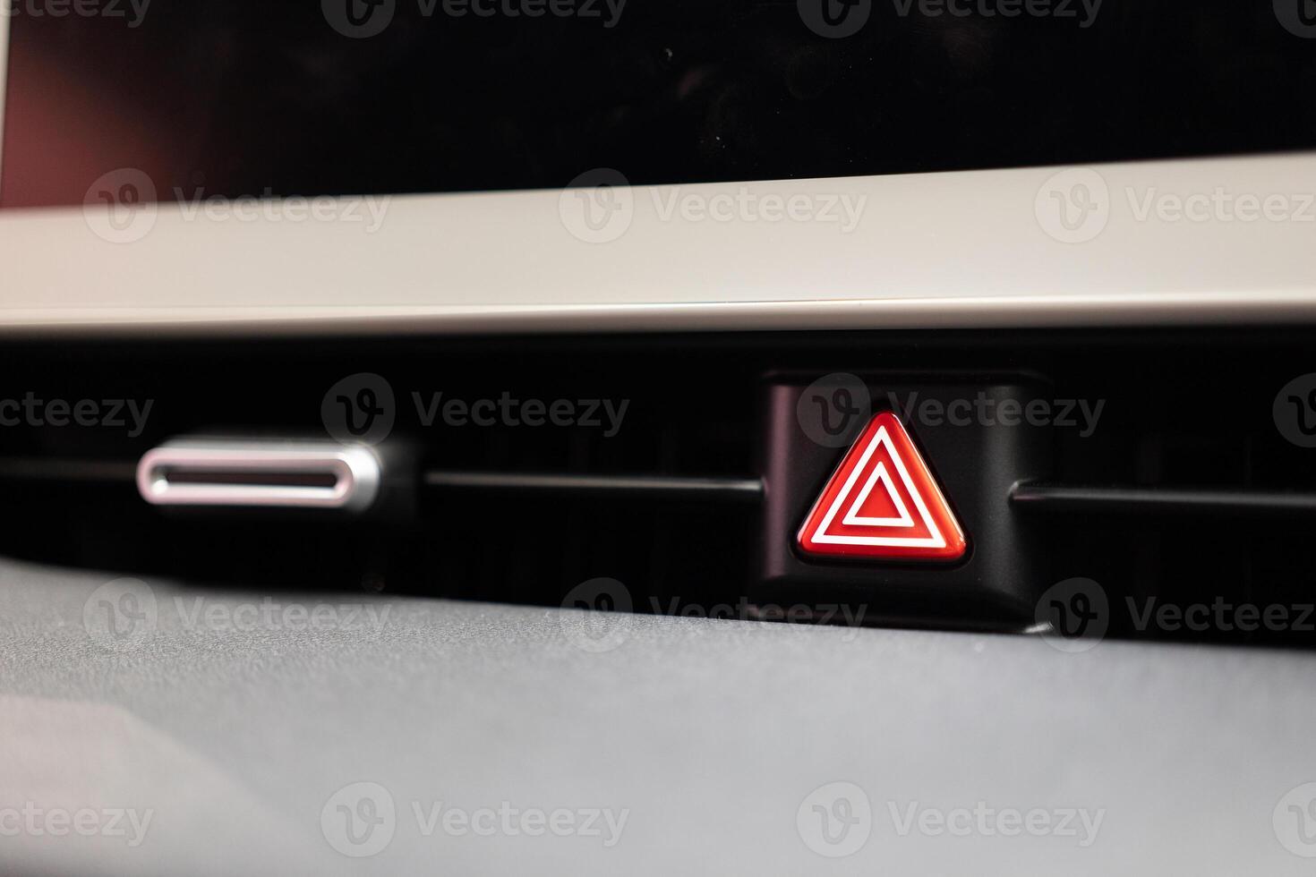 Emergency stop button in the car. Car emergency warning light button in front car console. photo