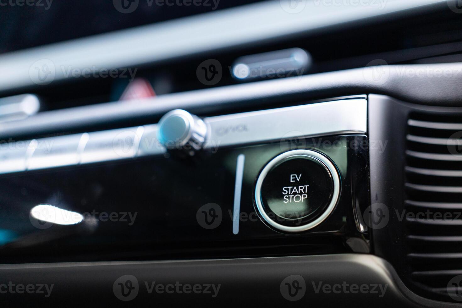 An electric vehicle EV engine start stop button on textured background. Copy space. photo