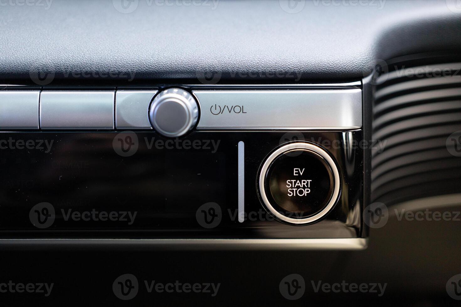 An electric vehicle EV engine start stop button on textured background. Copy space. photo