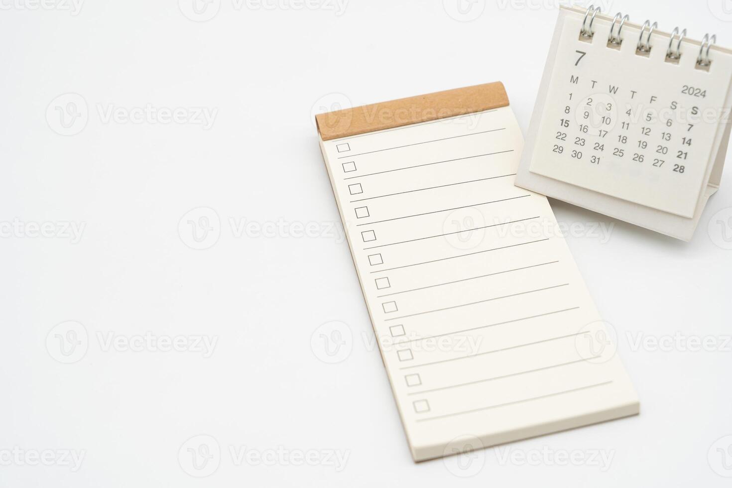 blanco cheque lista o vacío pequeño bloc para texto con caja y sencillo escritorio calendario para julio 2024. blanco a hacer lista para texto en julio. Copiar espacio. foto