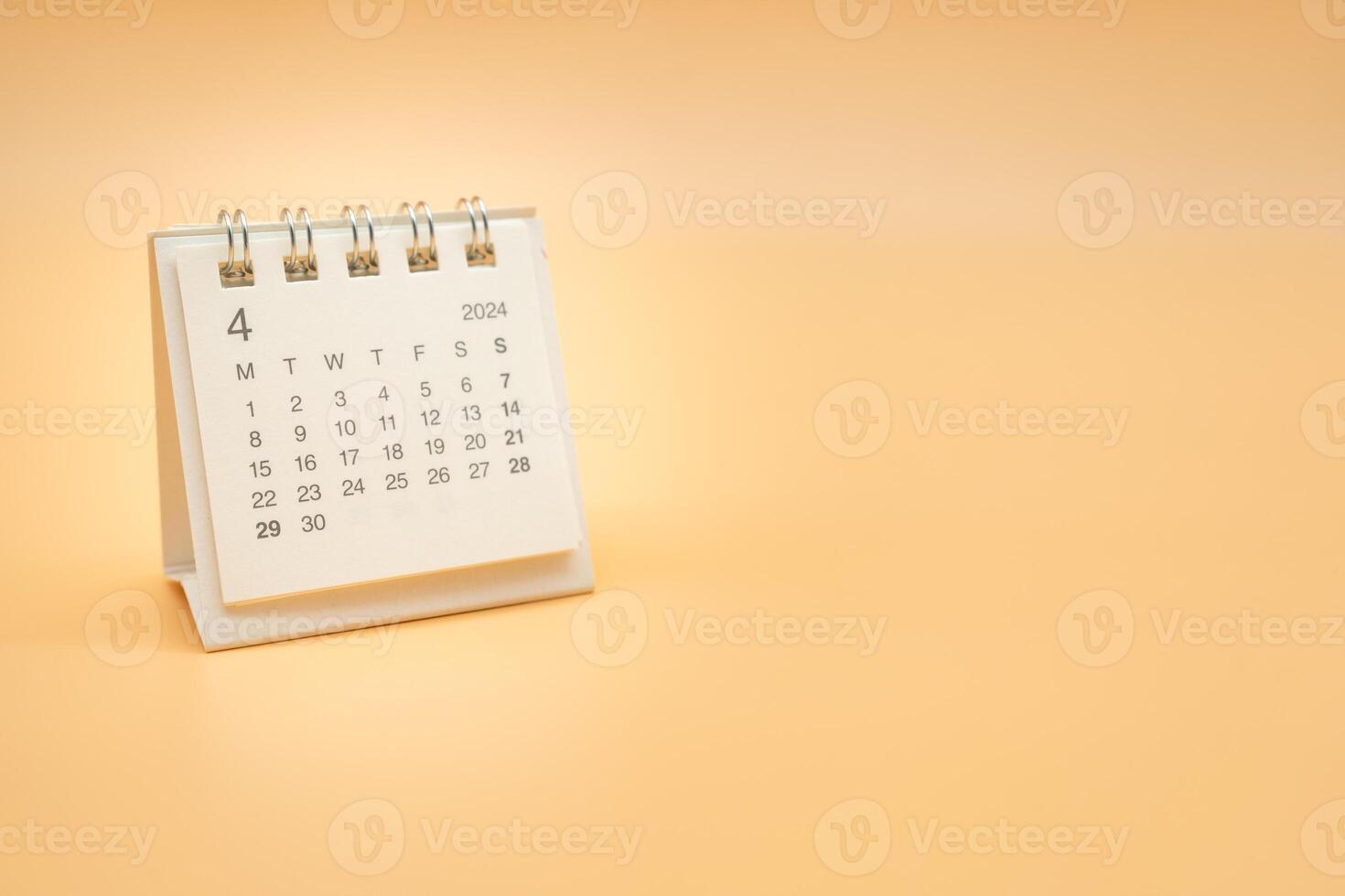 Simple desk calendar for APRIL 2024 isolated on orange background. Calendar concept with copy space. photo