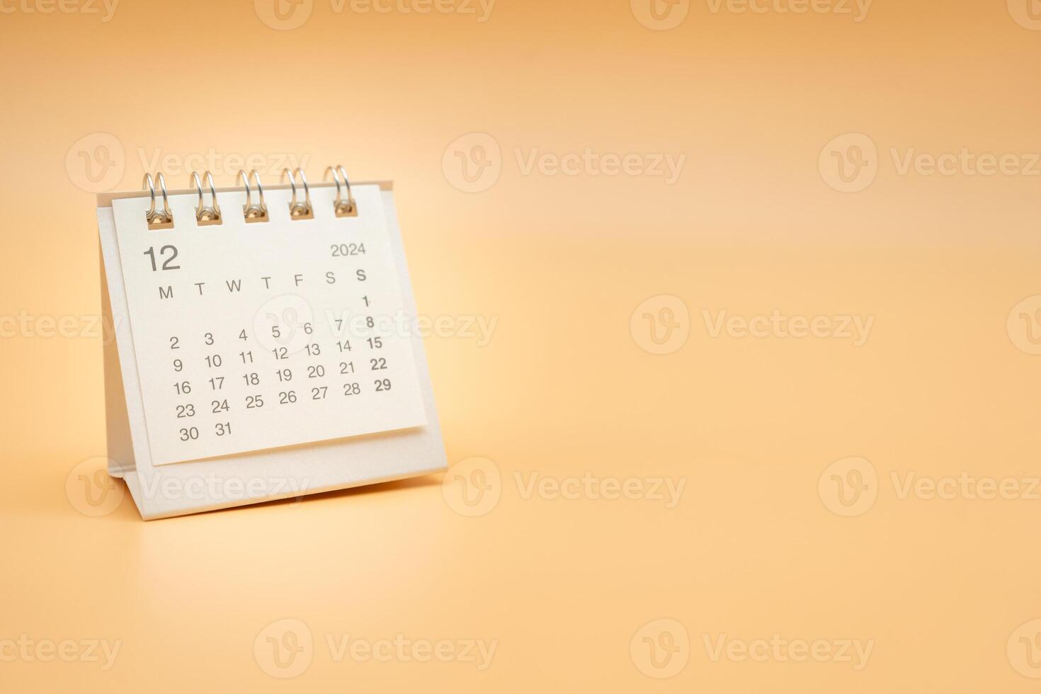 Simple desk calendar for December 2024 isolated on orange background. Calendar concept with copy space. photo