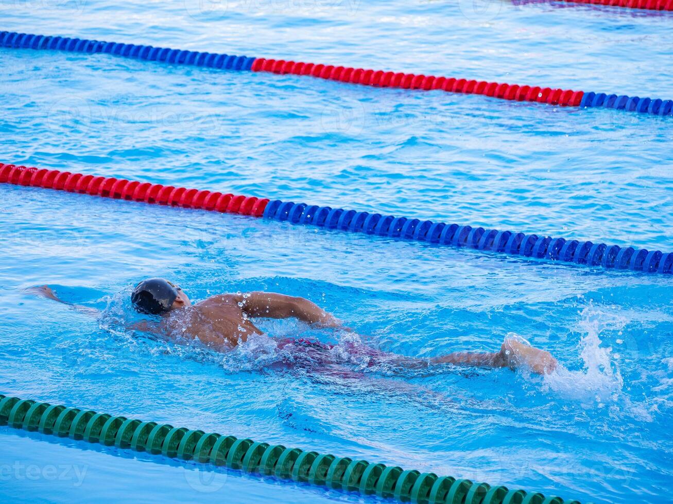 A young man swimming in an outdoor pool. Close-up photo. Concept of sport and healthcare photo