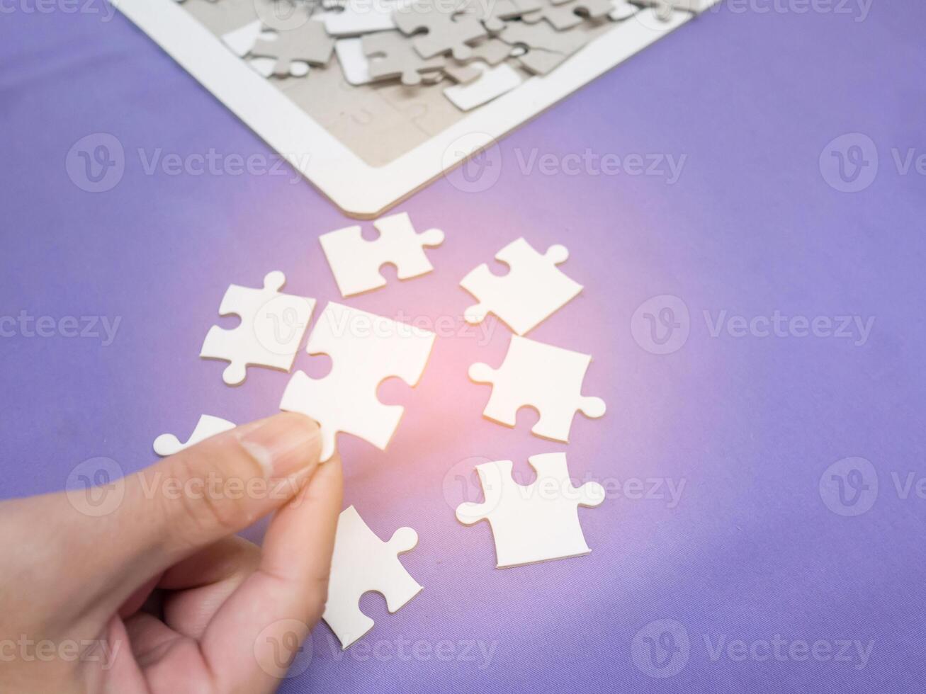 Hand of a young man holding a jigsaw puzzle with sunlight effect photo