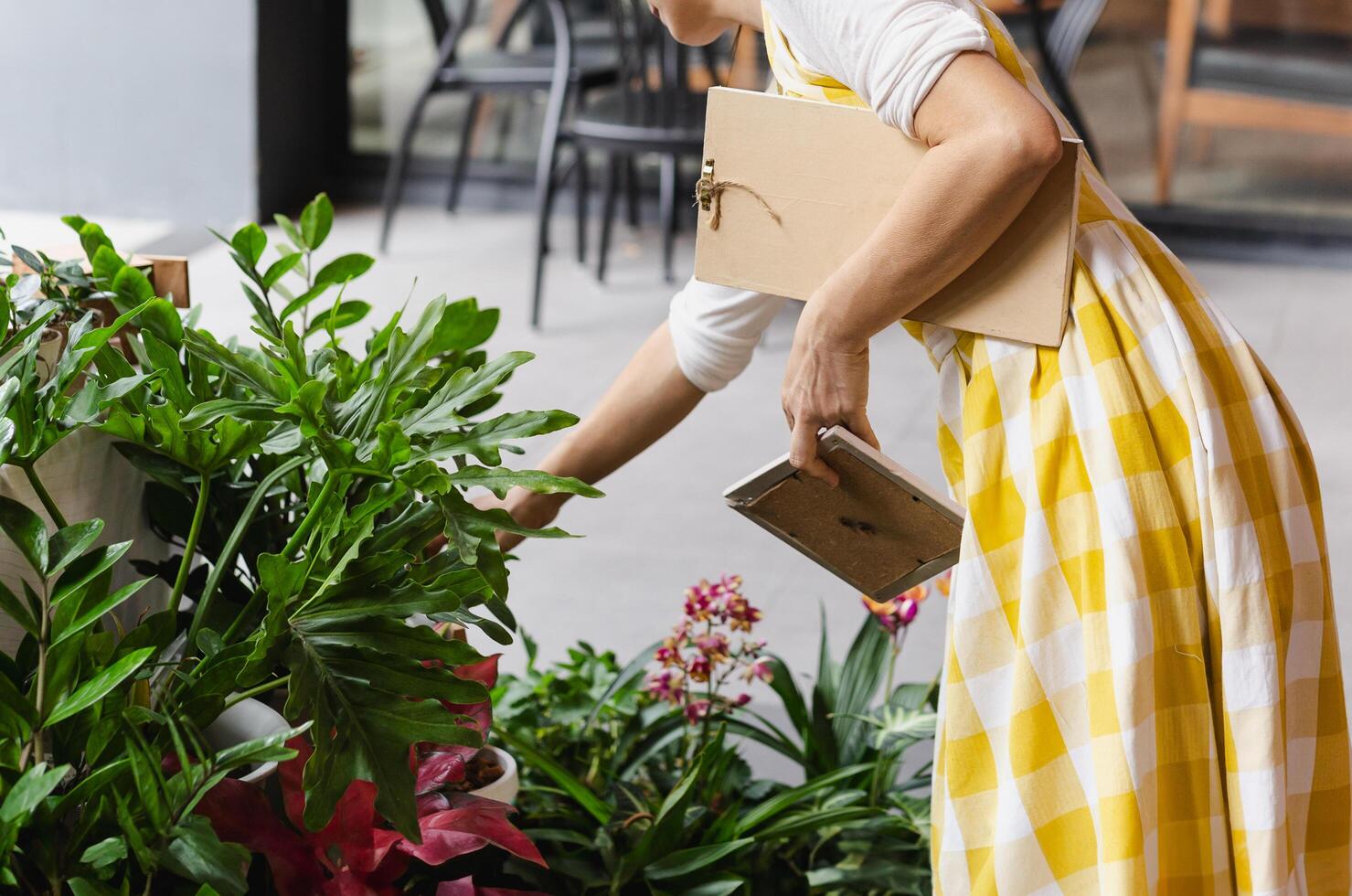 Cropped shot of unrecognizable woman holding potted flower plant in garden shop. photo