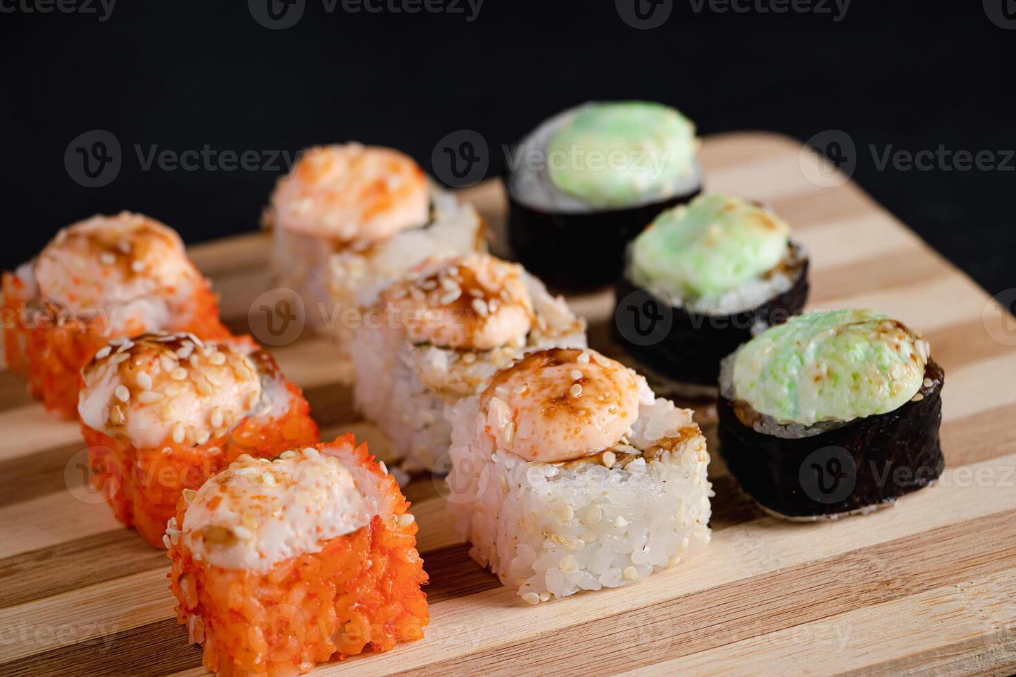 Set of sushi rolls on bamboo serving tray. Uramaki and futomaki roll photo