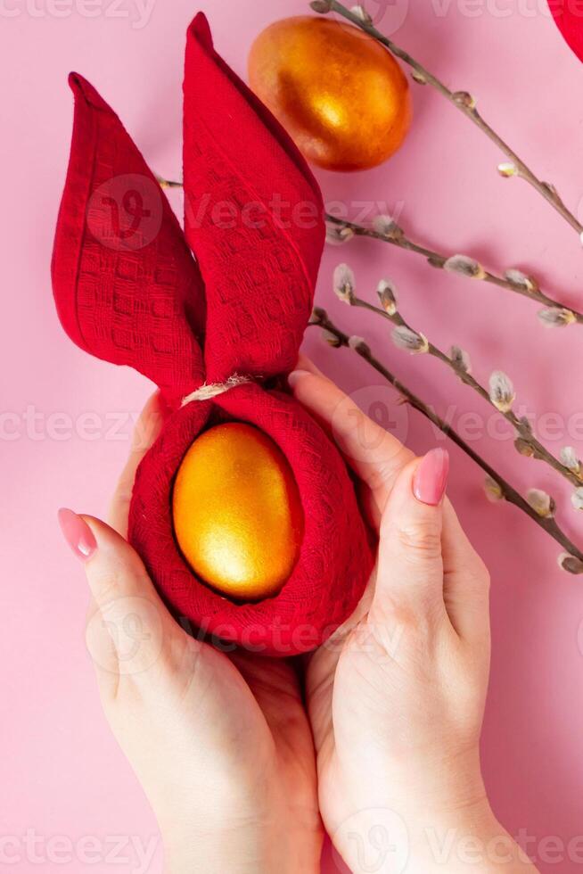 Woman holds a shiny Easter golden egg in her hand. photo