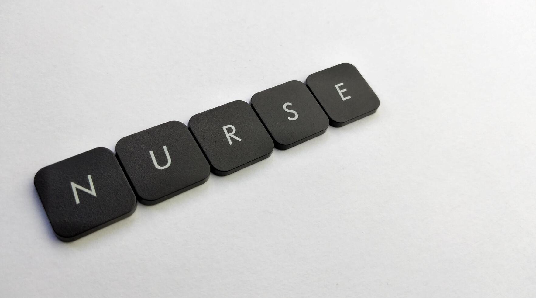 The word NURSE written with black buttons on a white background photo