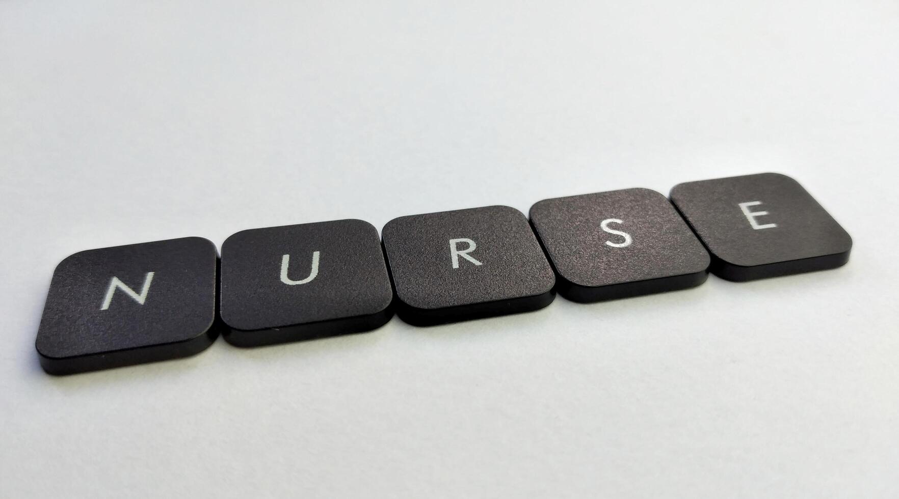 The word NURSE written with black buttons on a white background photo