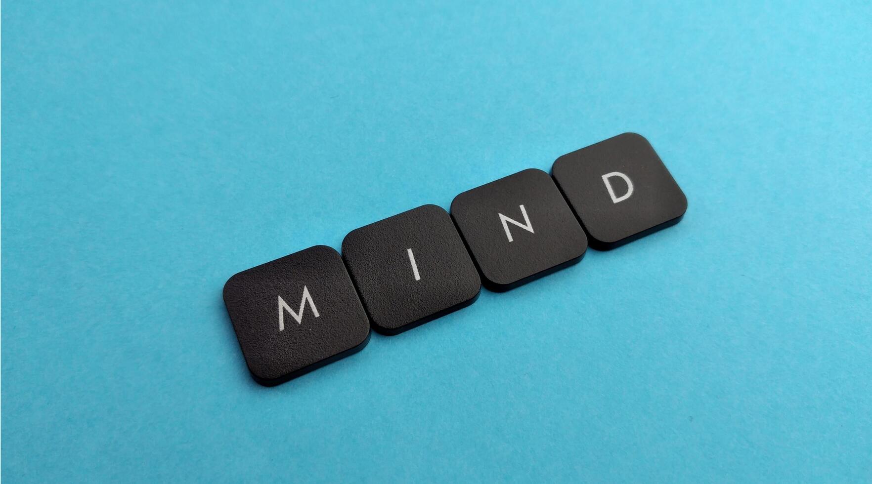 MIND word on black keyboard button on blue background, business and education concept photo