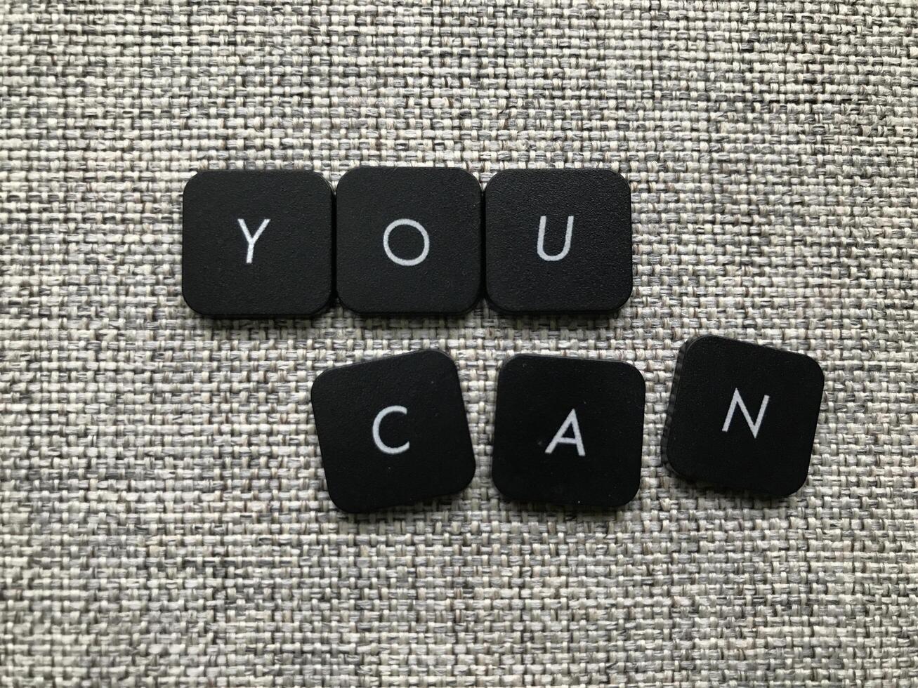 You can word made of black letters on gray fabric, top view photo