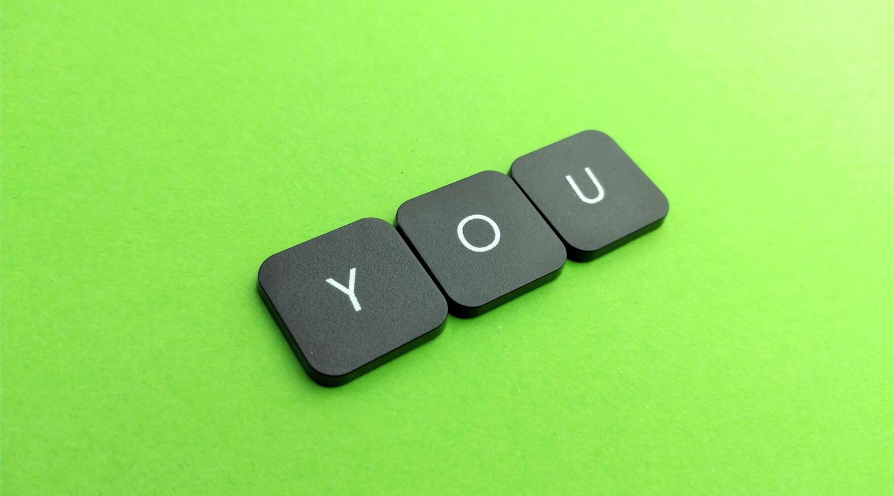 word you on black button on green background, business and finance concept photo