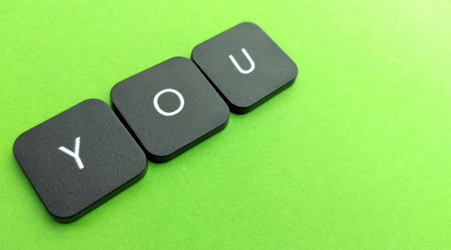 word you on black button on green background, business and finance concept photo