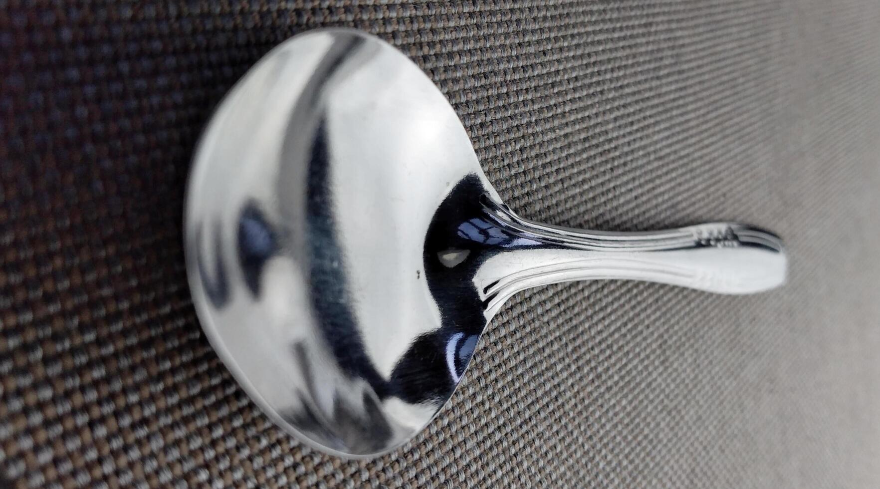 Close up of a silver spoon on a black background. Selective focus. photo