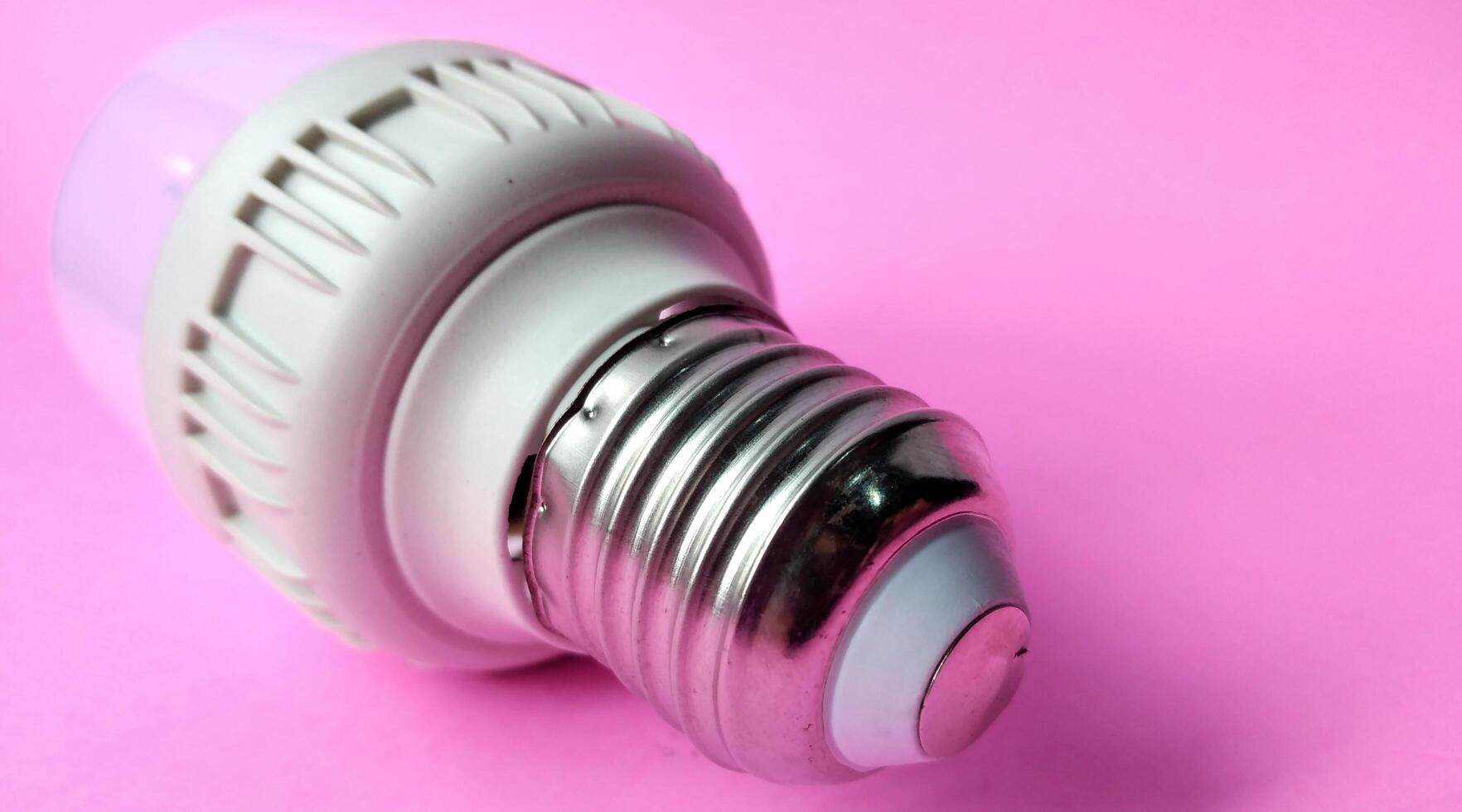 energía ahorro LED ligero bulbo en rosado antecedentes. energía ahorro concepto. foto