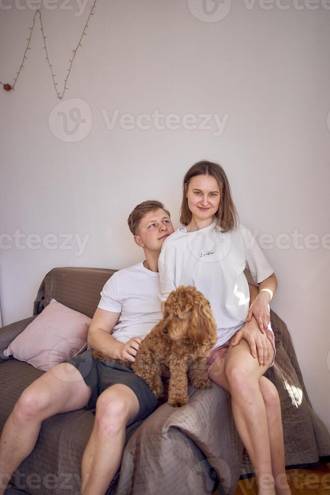 a young couple in home clothes gently hug in the living room, minimalism photo