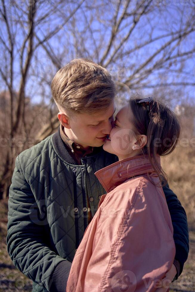 young man and woman kissing on a bright sunny day photo