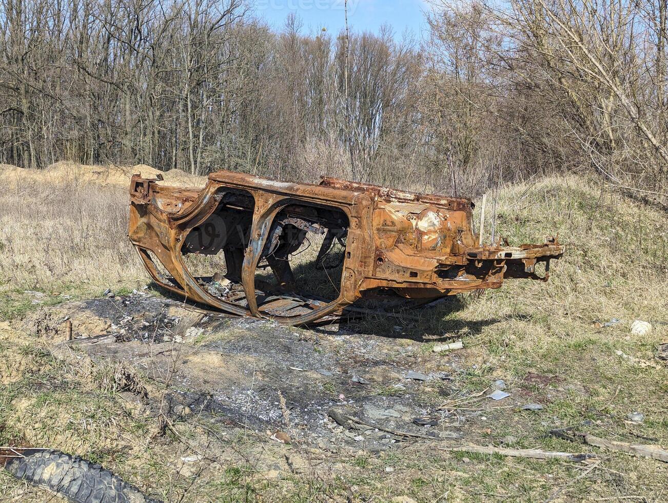 the old car was destroyed in the russian war upside down in forest photo