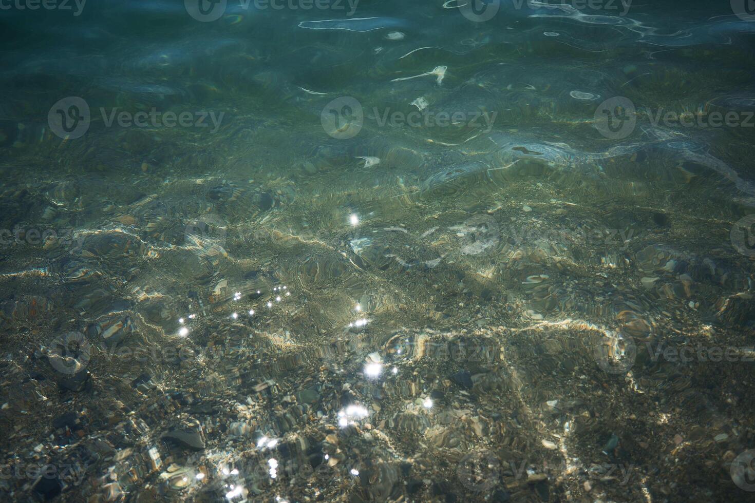 transparent turquoise water of the lake with flashes of light photo