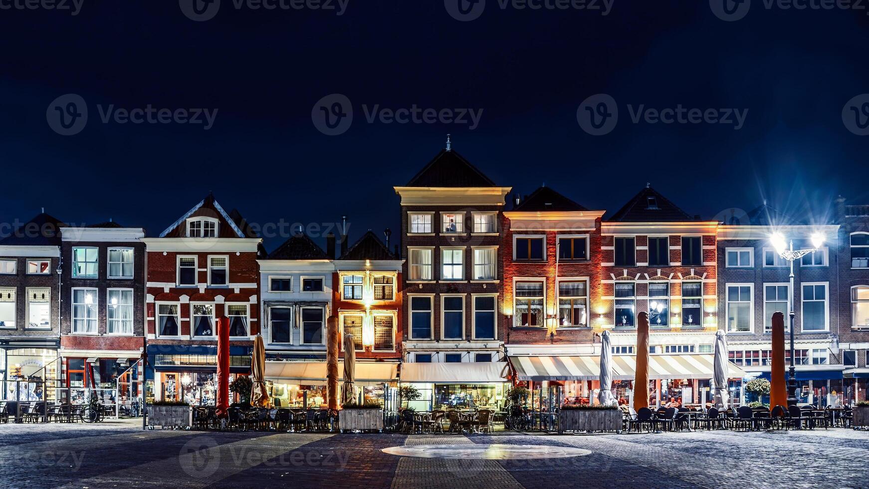 Nighttime View of Historic Row Houses and Cafes in Market Square, Delft, Netherlands photo