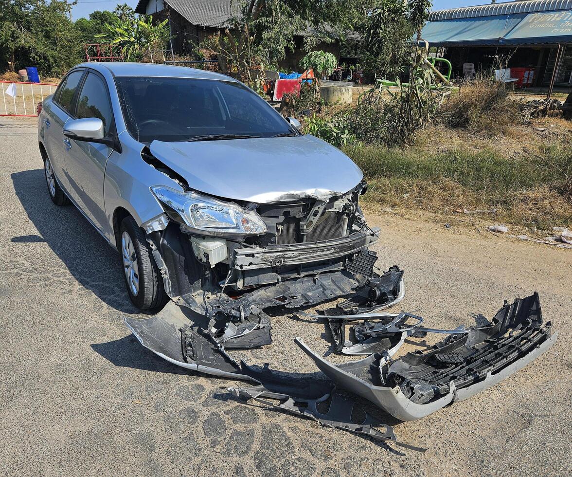 Bronze, gray or grey car broke or accident and crash with 6 wheel truck with trailer on street or road. Damaged or injured on front bumper and car radiator. Broken and insurance of vehicle concept. photo