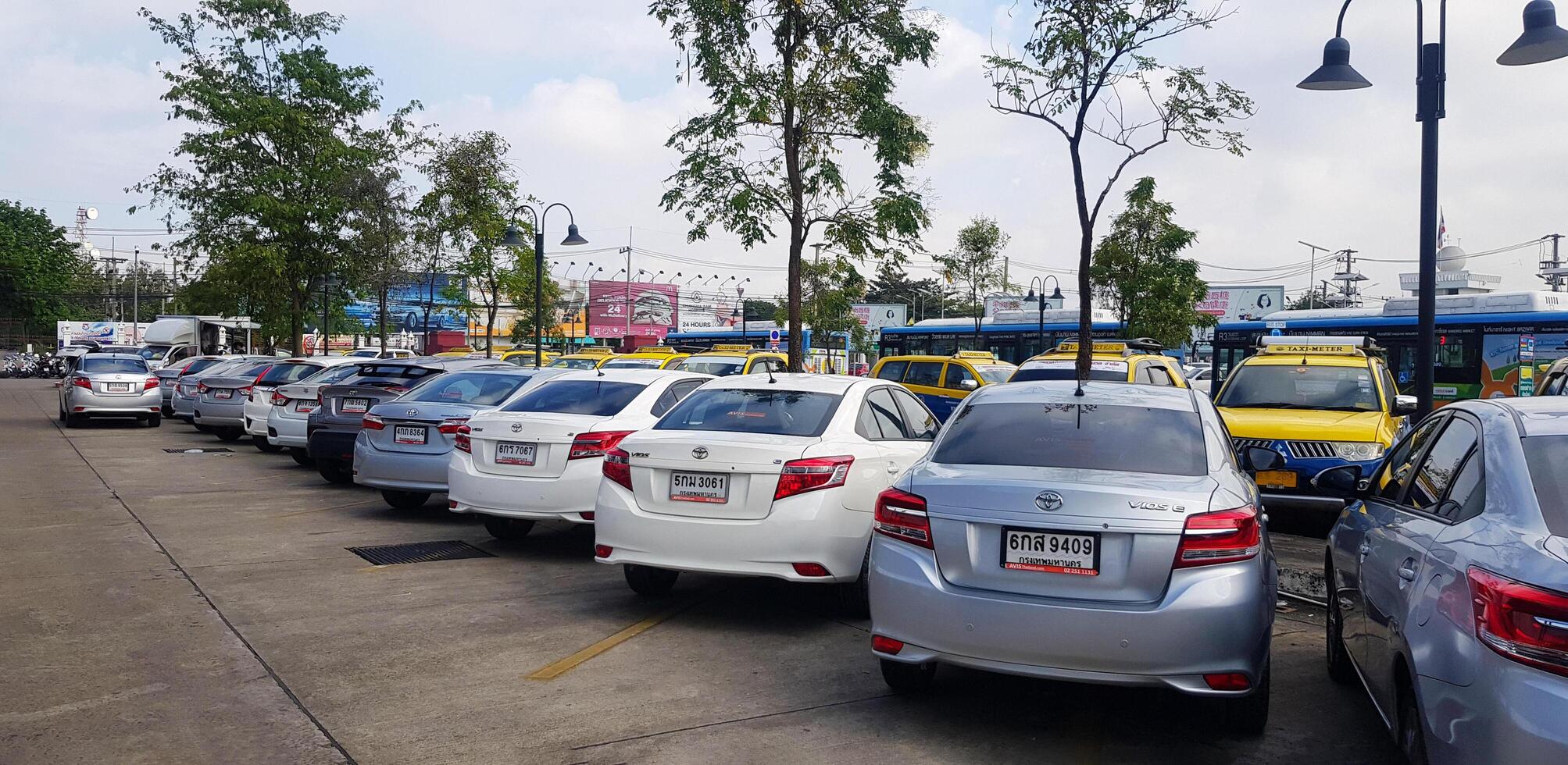 Chiang Mai,Thailand - January 28, 2024 Many cars parked for rent, taxi and buses for pick up passengers on parking near airport. Travel, vehicle and Transportation. photo