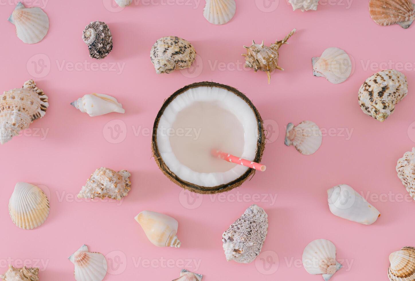 Tropical beach concept made of coconut fruit and sea shells on pastel pink background. Creative summer composition. Minimal layout. Trendy summertime party idea. Coconut and sea shells aesthetic. photo