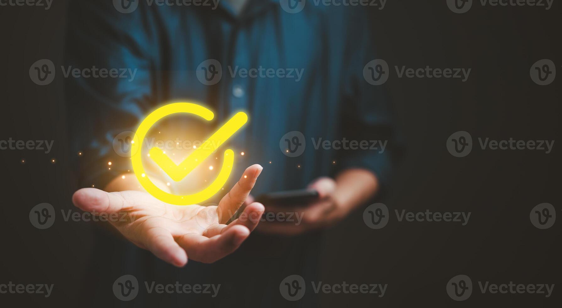 Man presents a luminous check mark, symbolizing the concept of approval, success, or quality assurance in a digital context. photo