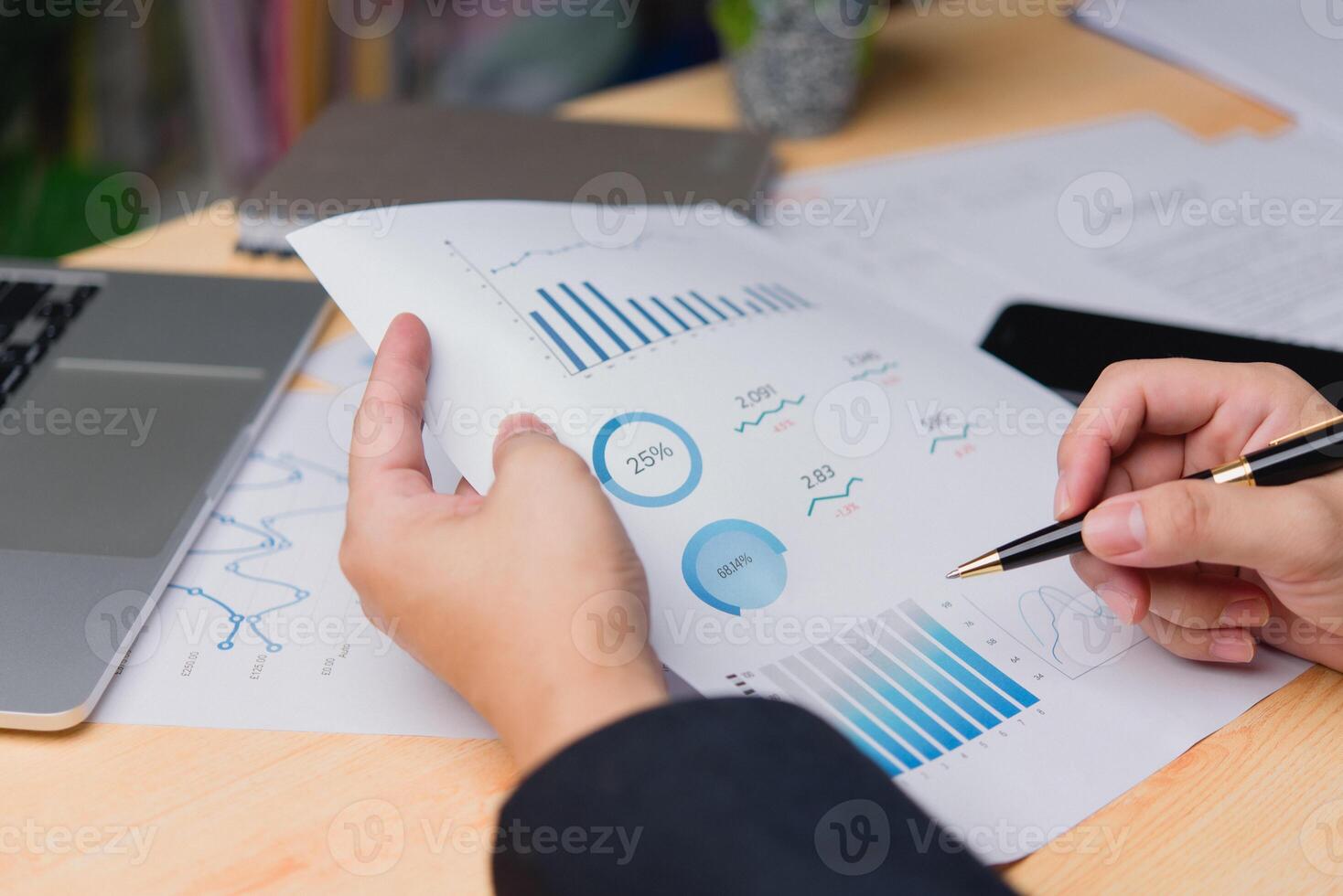 Close-up of a professional hand reviewing business document data performance analytics and printing statistical reports and planning marketing and financial strategy on a desk. photo