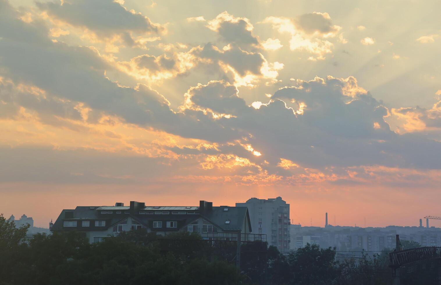 Beautiful sunrise with warm orange sunlight and beams through blue sky photo