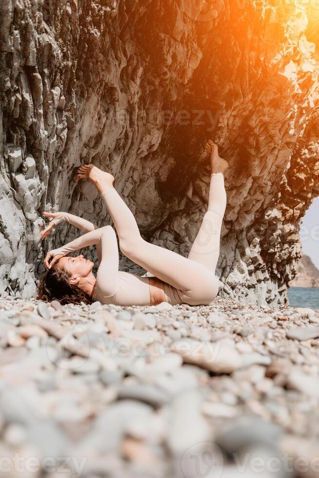 Woman travel sea. Sporty happy middle aged posing on a beach near the sea on background of volcanic rocks, like in Iceland, sharing travel adventure journey photo