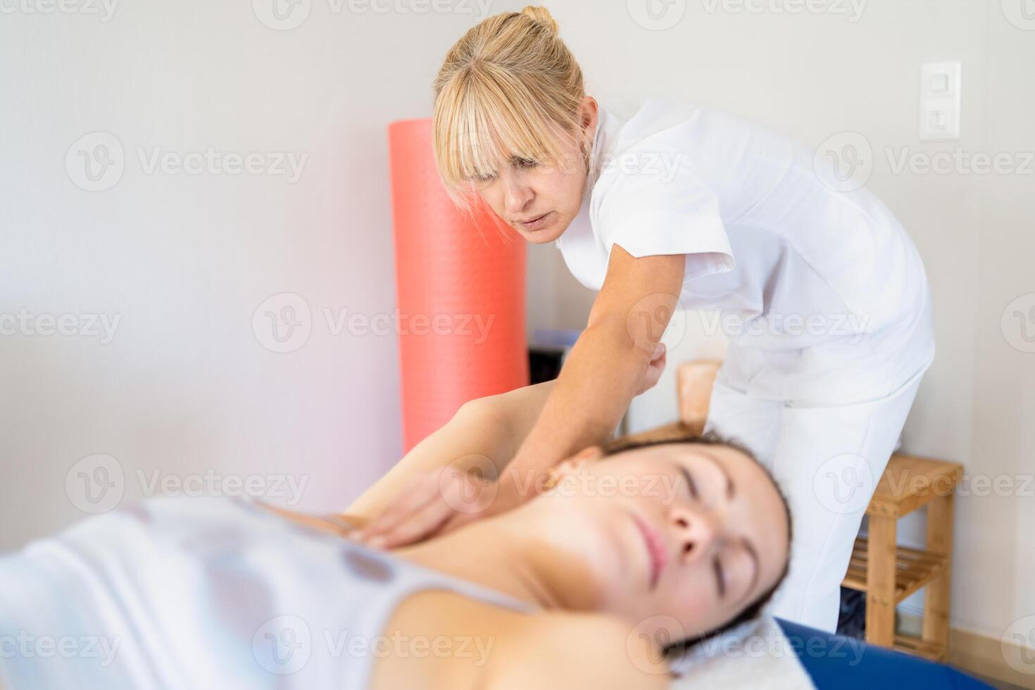 Professional osteopath manipulating arm of patient photo