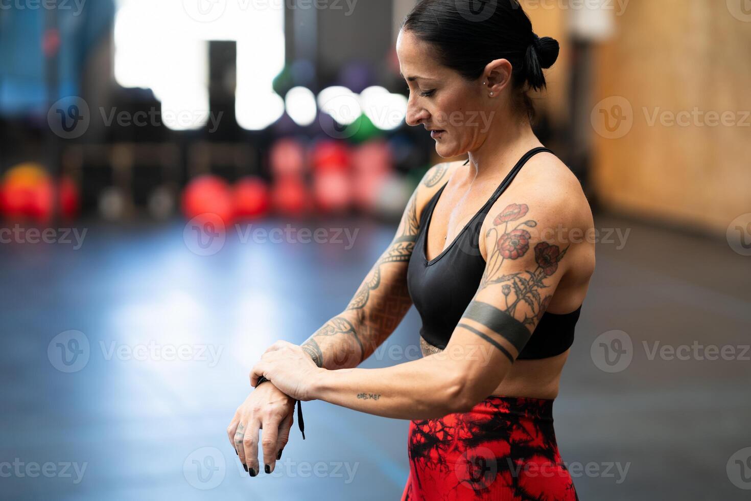 Woman wrapping her wrist to prevent injury on a gym photo