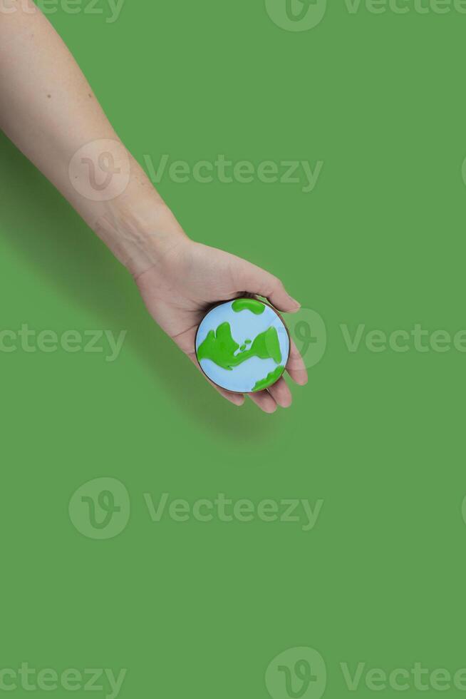 Earth Day concept. Cookie in shape of Earth in hand. photo