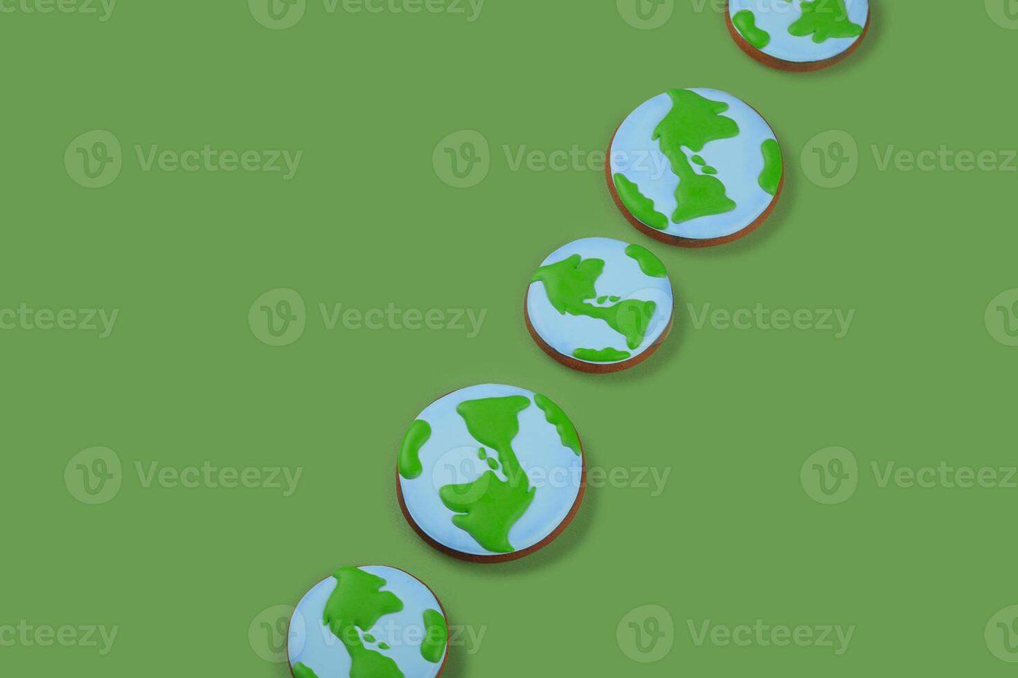 Earth Day concept. Cookies in shape of Earth on green backdrop. Copy space. photo