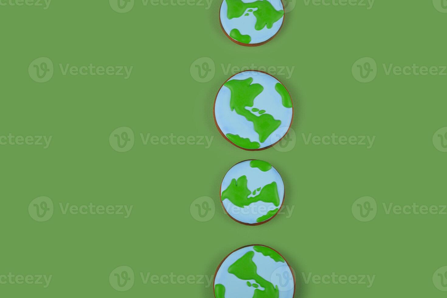 Earth Day concept. Cookies in shape of Earth on green backdrop. Background with copyspace. photo
