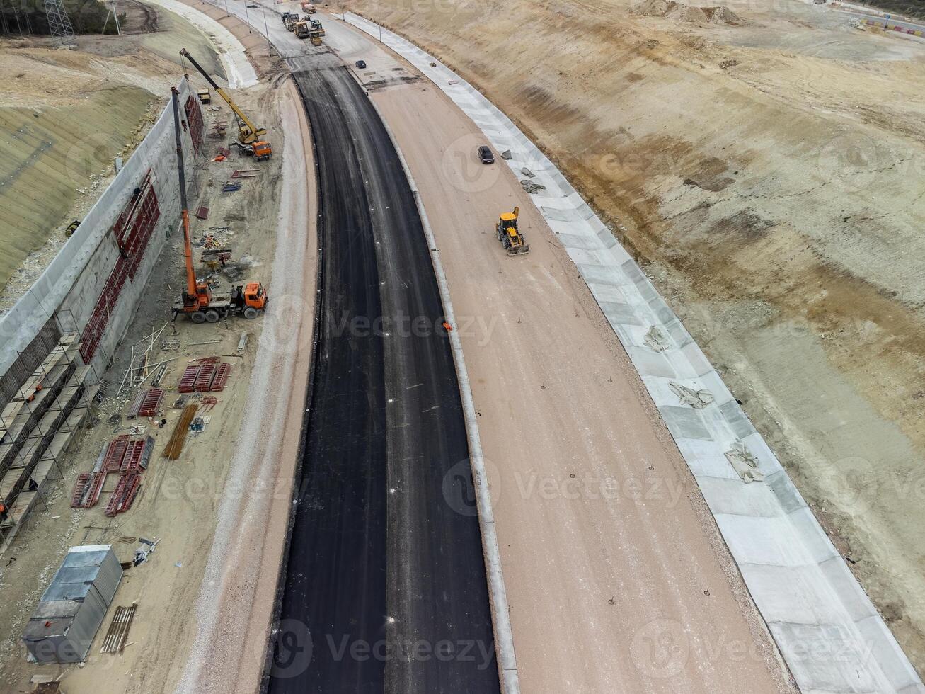 montaña la carretera constricción. trabajadores reforzarse el Pendiente terminado el nuevo la carretera. la carretera construcción en Progreso en Pendiente naturaleza cañón. infraestructura desarrollo y logística. aéreo zumbido Disparo foto