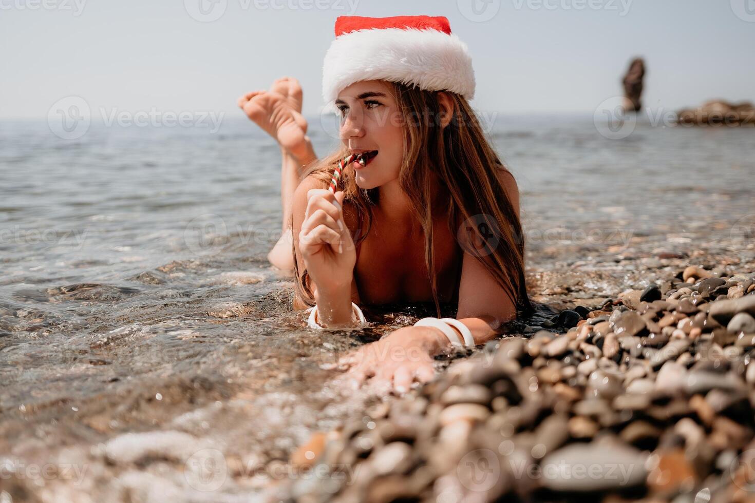 mujer viaje mar. contento turista disfrutar tomando imagen en el playa para recuerdos. mujer viajero en Papa Noel sombrero mira a cámara en el mar bahía, compartiendo viaje aventuras viaje foto