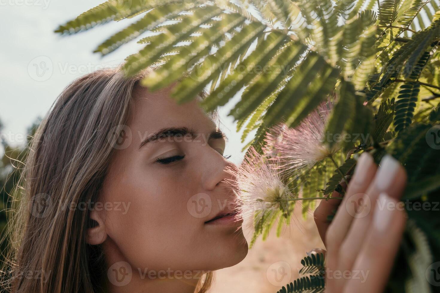 belleza retrato de contento mujer de cerca. joven niña oliendo chino acacia rosado cierne flores retrato de joven mujer en floreciente primavera, verano jardín. romántico onda. hembra y naturaleza foto