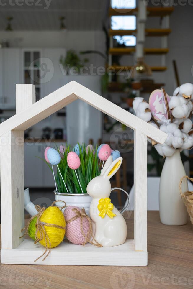 Tiny house of cozy home with Easter decor with rabbit and eggs on table of kitchen. Building, design, project, moving to new house, mortgage, insurance, rent and purchase real estate photo