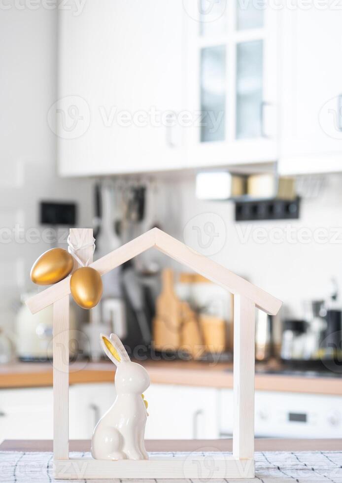 Tiny house of cozy home with Easter decor with rabbit and eggs on table of kitchen. Building, design, project, moving to new house, mortgage, insurance, rent and purchase real estate photo