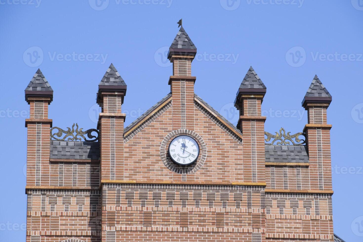 Clock on the wall of a brick building. Brown brick building with boshni and hours. photo
