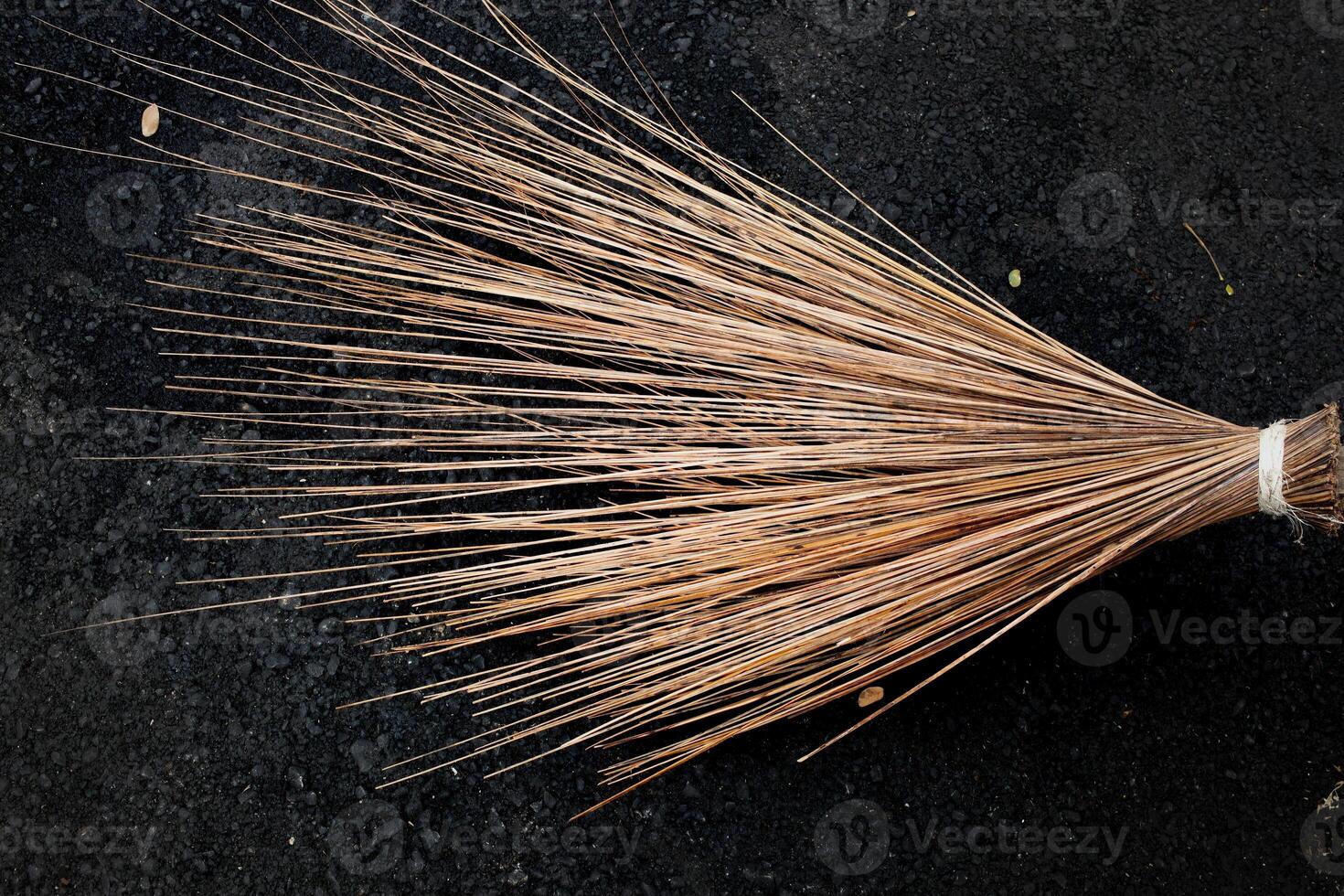 The texture of the palm fiber broom, which is often used to sweep floors or clean dirty wall surfaces, can be seen from the front with natural lighting. photo