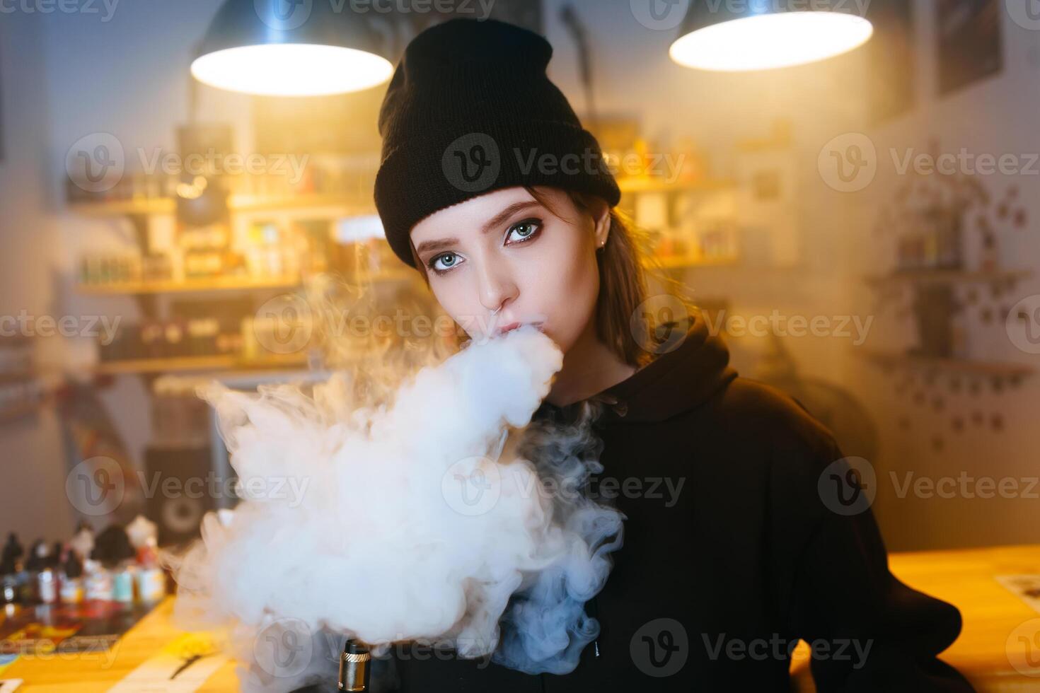 Vaping girl. Young hipster woman vape e-cig at the vapeshop. Hip-hop style. Closeup. photo