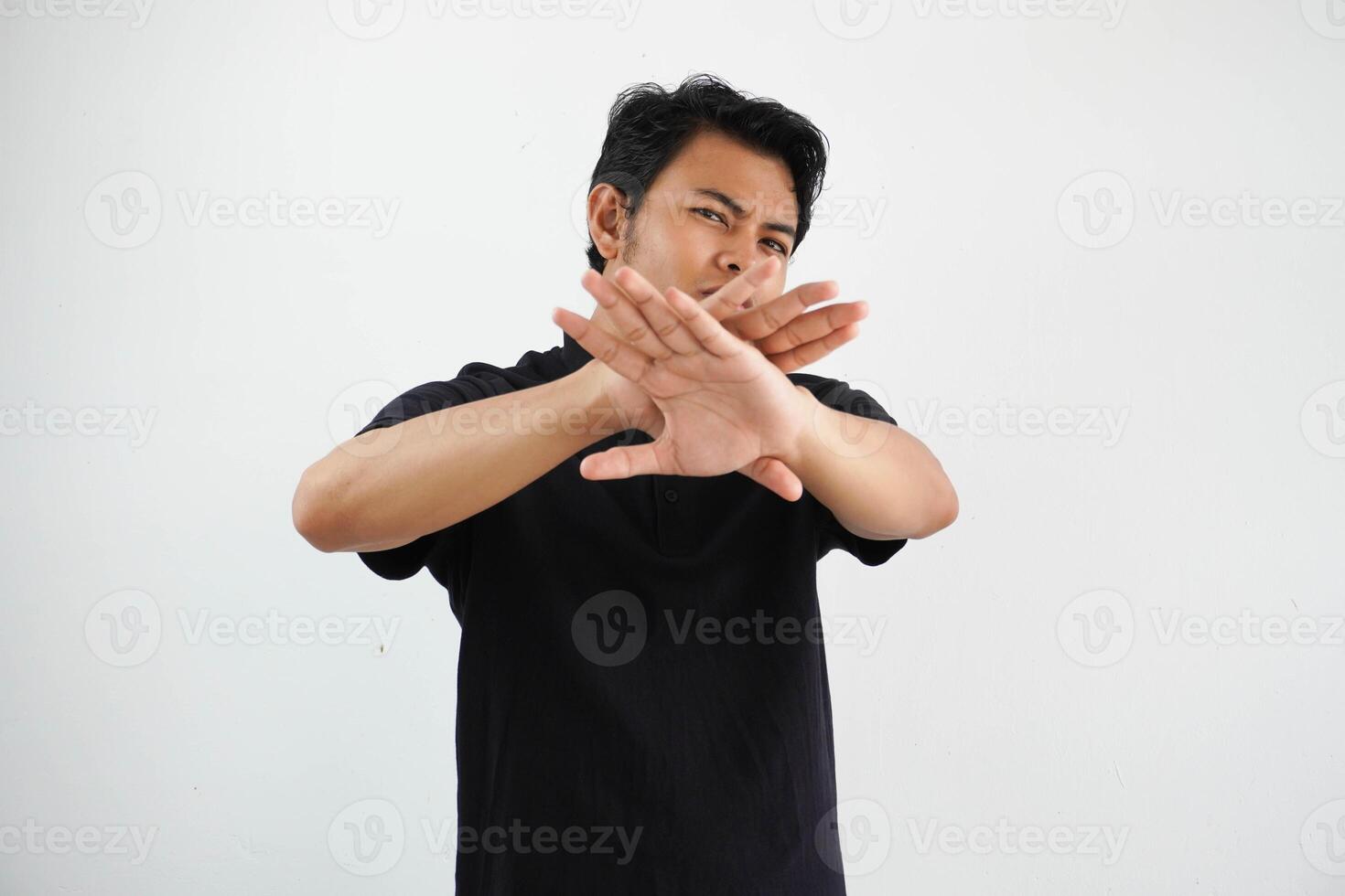 young asian man making stop gesture with her hand to stop an act wearing black polo t shirt isolated on white background photo