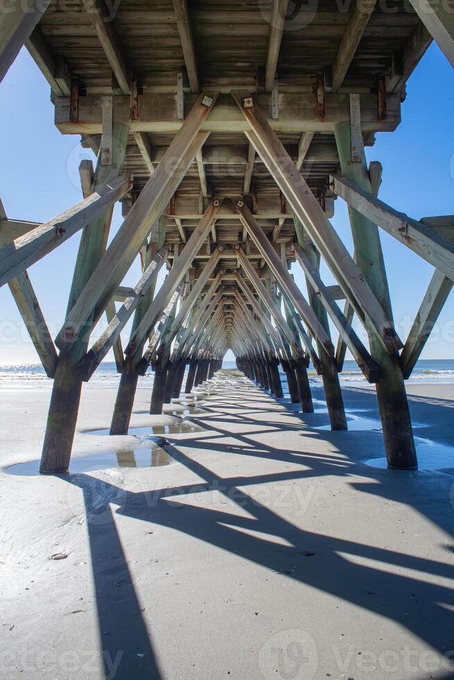 Looking out Under a Fishing Pier with Shadows Cast from Pilings photo